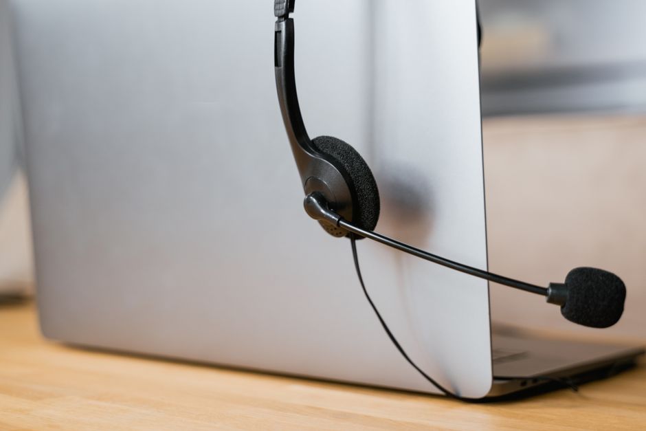 Prijenosno računalo s priključenim slušalicama za udaljenu IT podršku i online sastanke